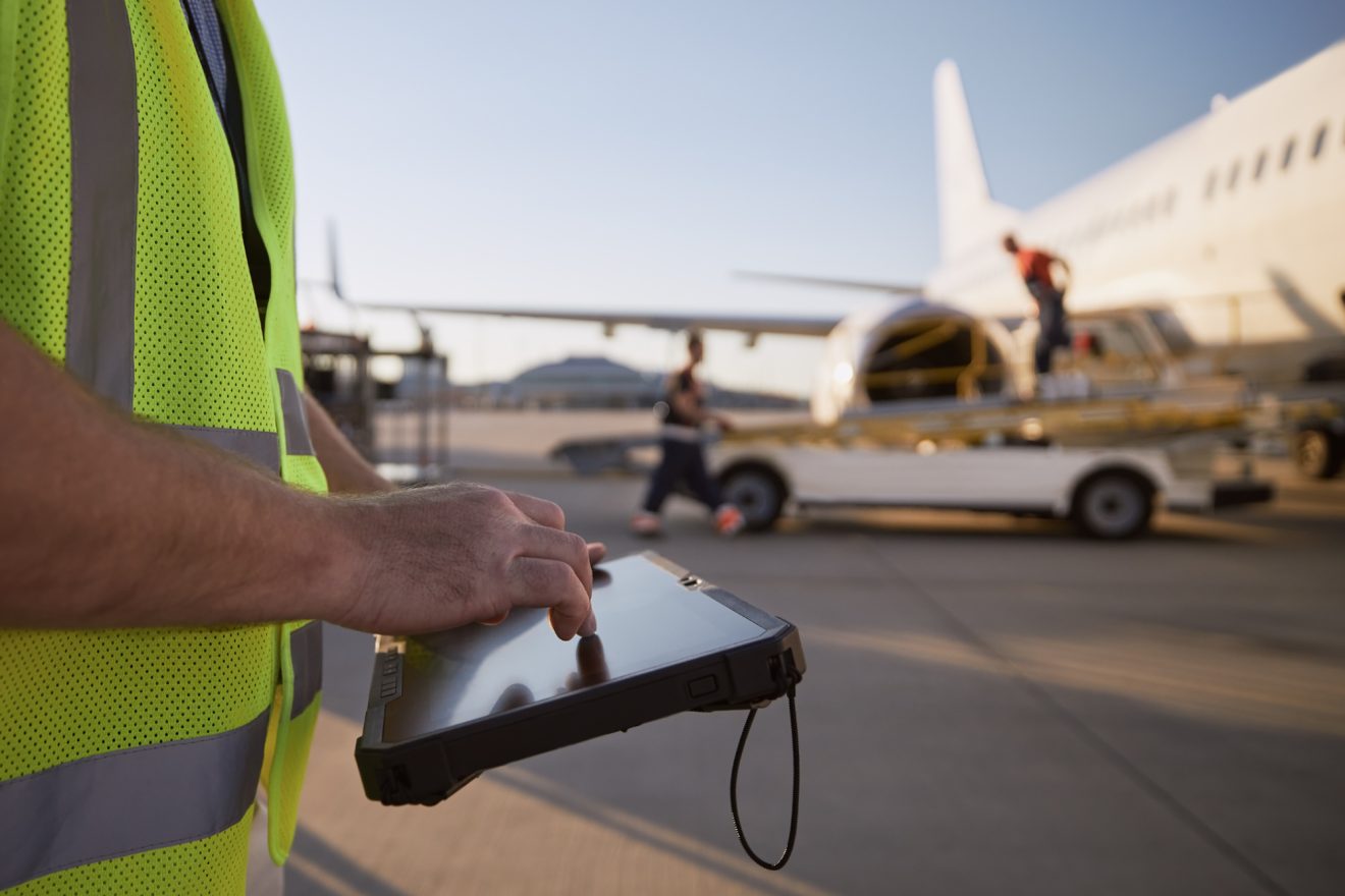 A person uses a tablet to keep track of plane scheduling