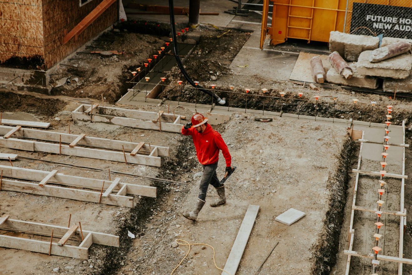 A man in a hard hat crosses a job site