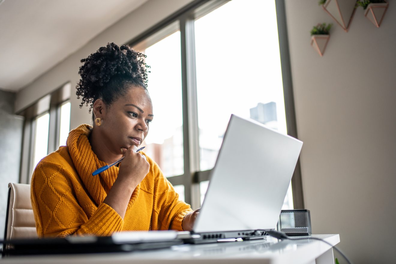 Woman sitting at desk, working on laptop