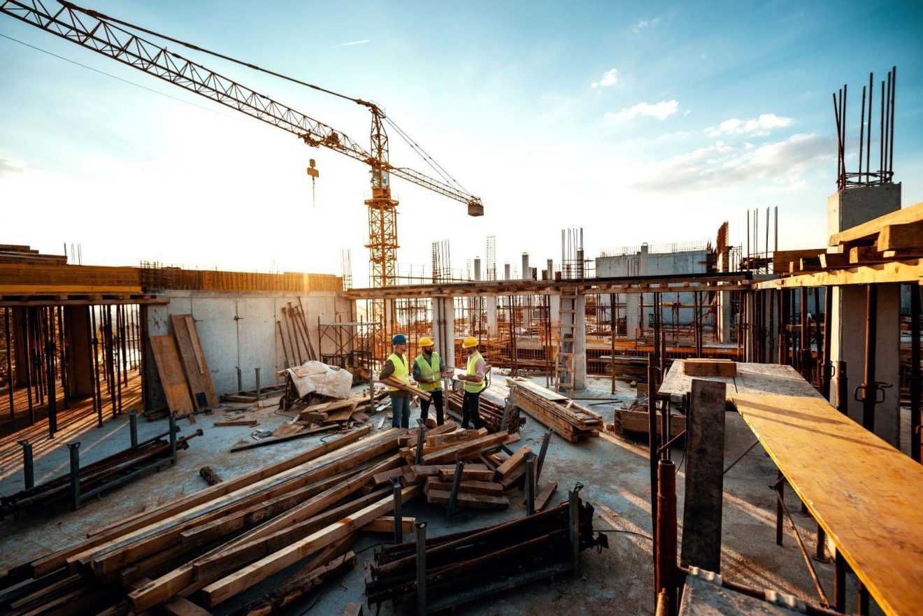 Three people work on a construction site
