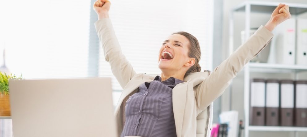 portrait of happy business woman in office rejoicing success