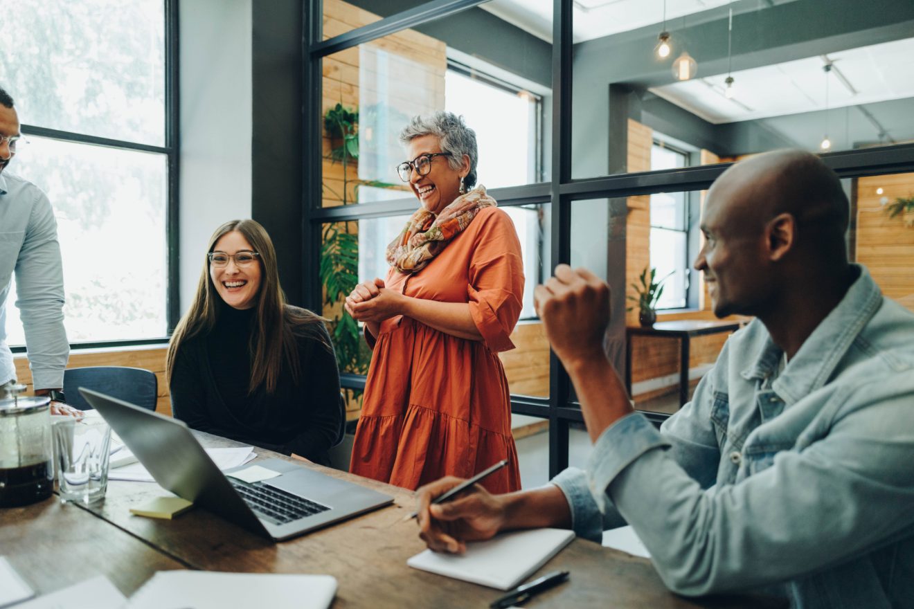 Group of businesspeople smiling cheerfully during a meeting in a modern office