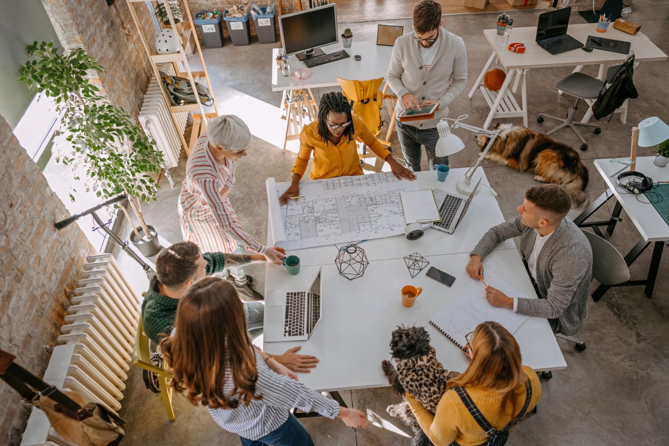 Multi-ethnic group in an architectural layout discussion in office