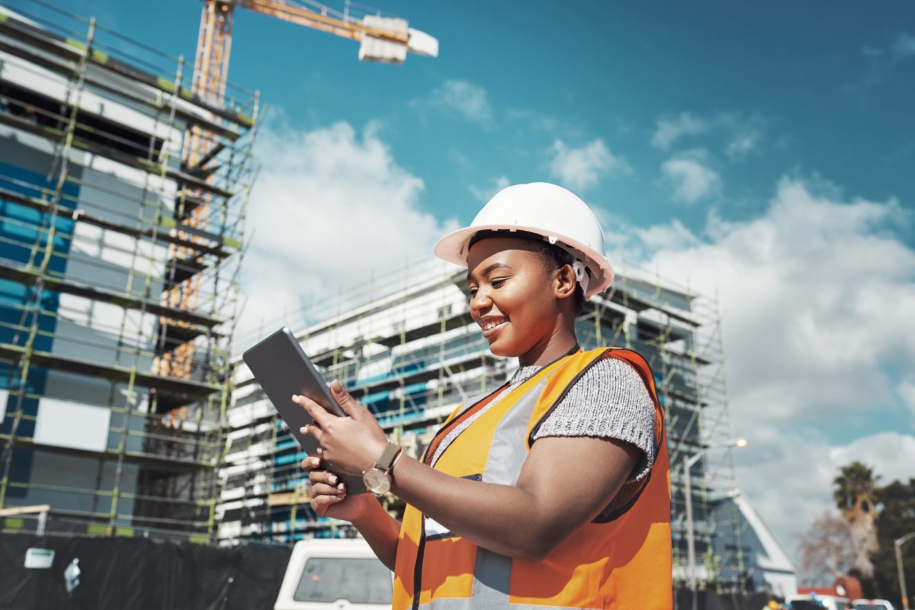 A construction worker consults her iPad on site