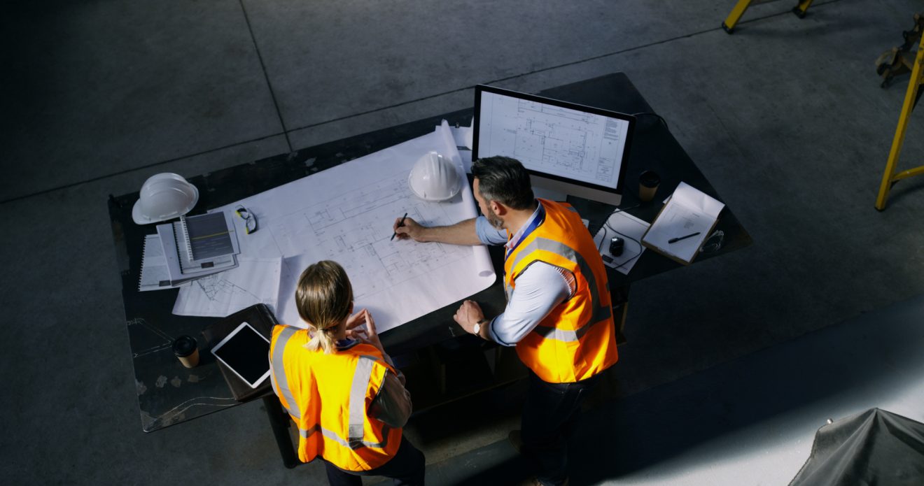 Two construction workers look at build details