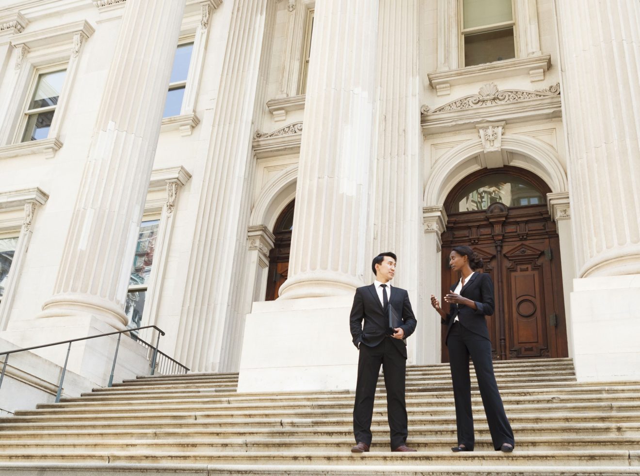 Two government workers walk down the stairs of their building