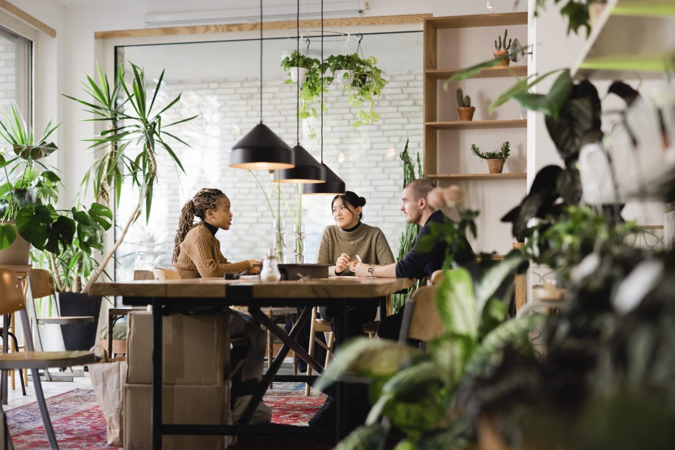 Three people work together at a collaborative table in the office