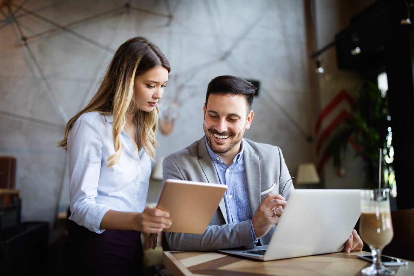 Two people discuss data from a tablet
