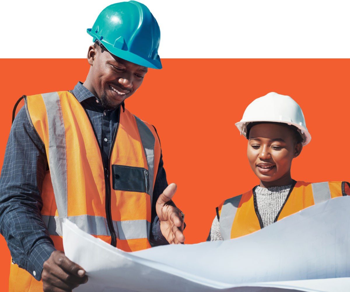 Two people look at blueprints at a construction site