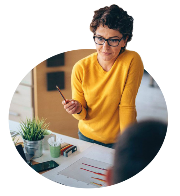 Woman in office in yellow sweater holding pencil